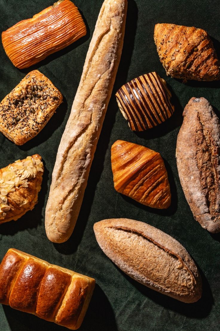 An assortment of finished breads showing different shapes and crusts