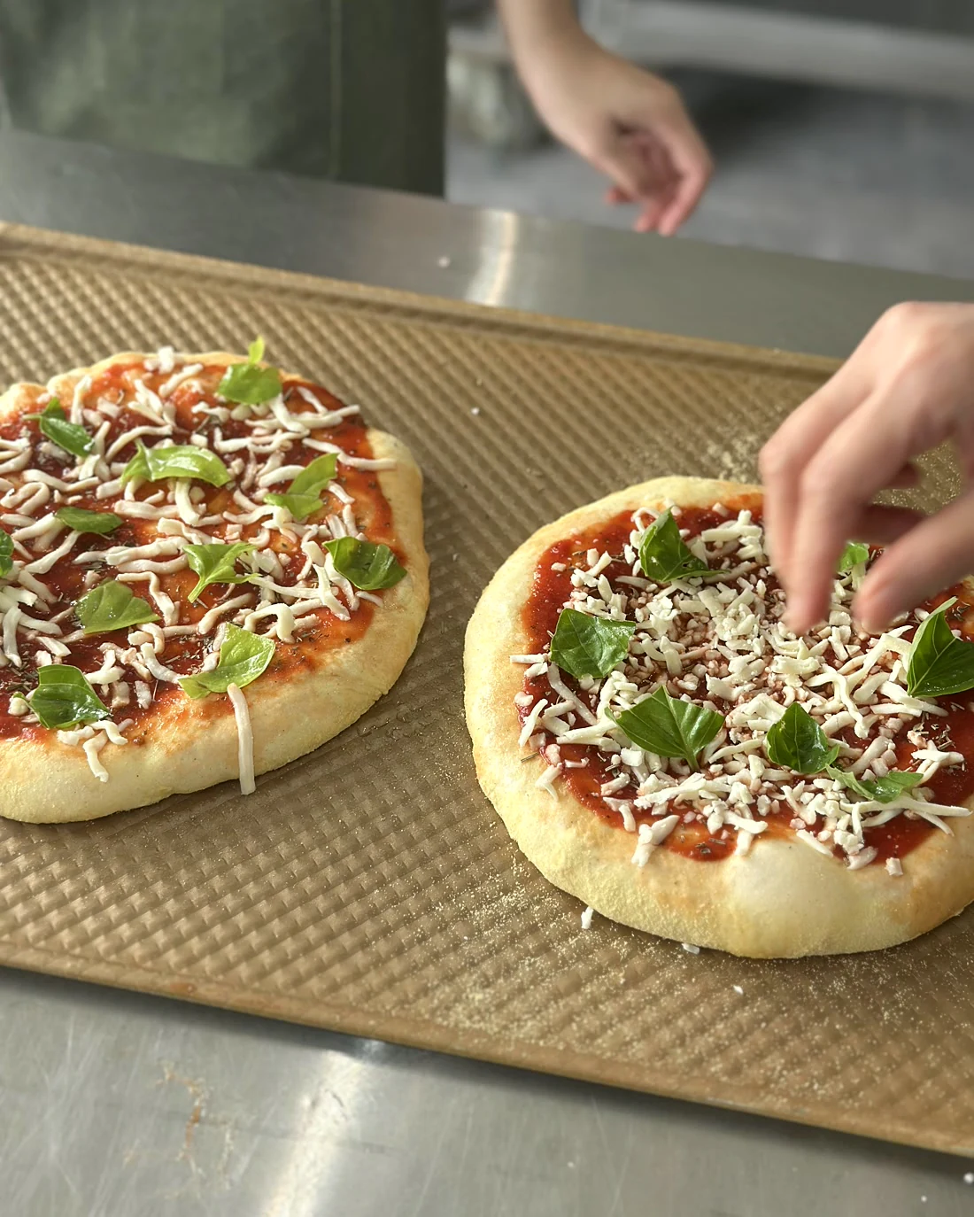 Real BWC pizza practical at JWC Academy, with students topping prepared pizza dough before baking